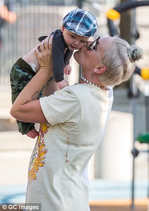 Smiles: The star was spotted giving the delighted tot a kiss